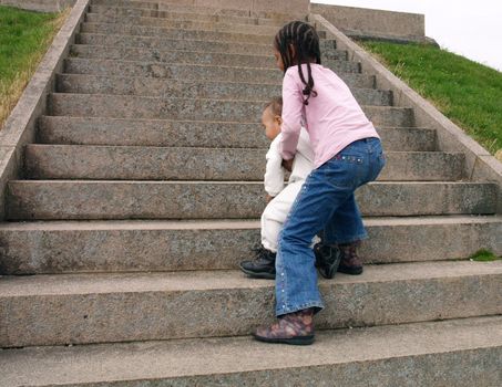girl helping sister up staircase