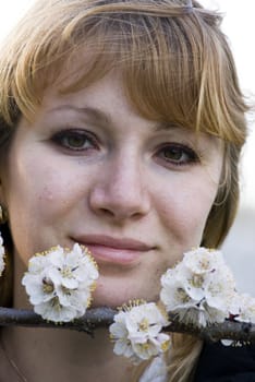 Fashion portrait of a beautiful blonde girl with flowers of apricot