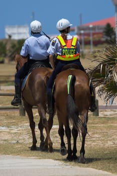 Local Police on horse back patrolling the beach