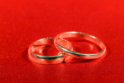 On a photo wedding rings on the red background

