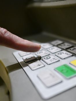 Finger using automatic teller keypad to enter pin number