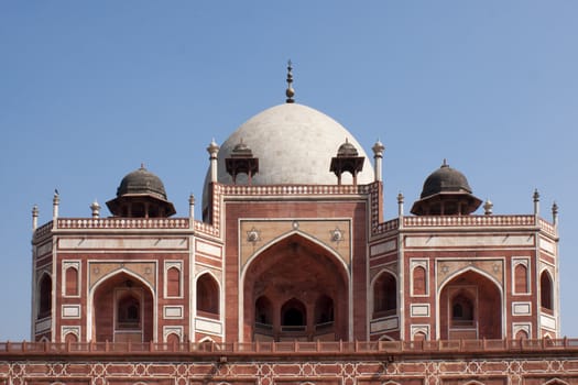 Symetric structure with white dome against blue sky.