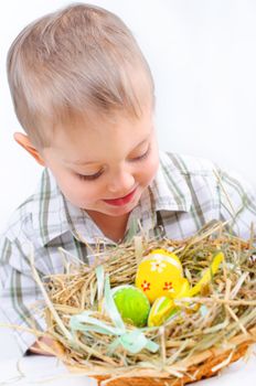 Little boy playing with easter eggs in basket