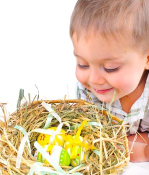 Little boy playing with easter eggs in basket