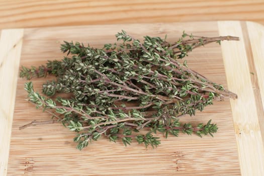 A bouquet of rosemary herbs on a weathered old chopping board.