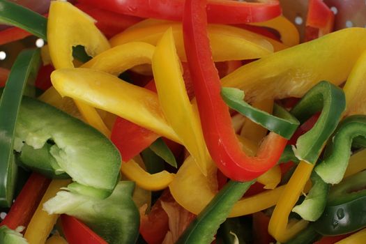 many pepper slices on a wooden background