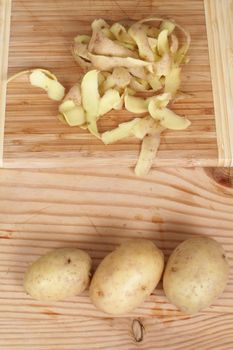 Peeling a potato with peeler in a kitchen