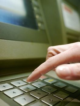 Finger using automatic teller keypad to enter pin number