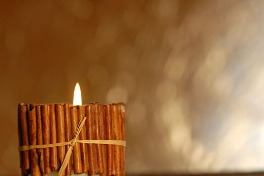 rustic candle burning on a golden background blur