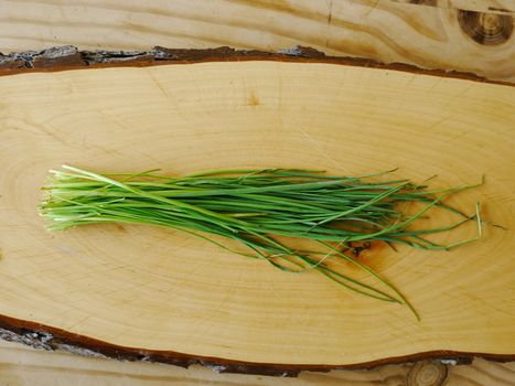 very fresh chives on a wooden surface