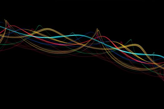 abstract background of colourful glowing light waves on black