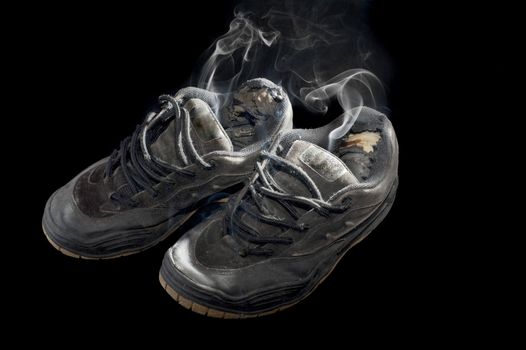rotten pair of dog-eared old sneakers on a black background