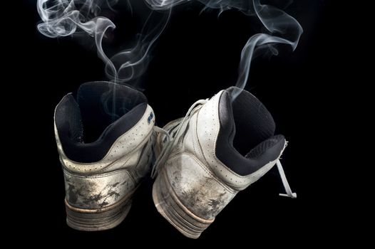 pair of rotten old sneakers on a black background