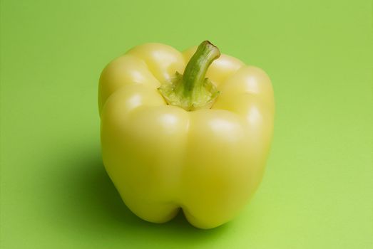 Yellow pepper on green background