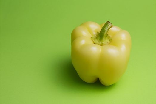 Yellow pepper on green background