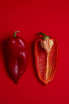 One and half Red Peppers on red background