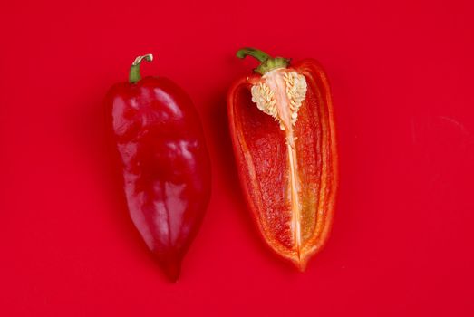 One and half Red Peppers on red background