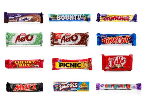 Various chocolate bars.  From left to right top to bottom,  Bubbly, Bounty, Crunchie, Aero Mint, Aero, Timeout, Cherry Ripe, Picnic, KitKat, Mars, Smarties, CurlyWurly.  Photographed in studio.  white background.