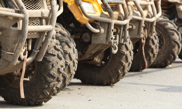 Low angle veiw of the front part of a row of ATVs.
