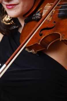 Woman in black dress holding violin in hand