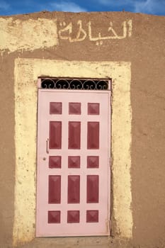 Close up of a typical Moroccan wood door painted with red squares