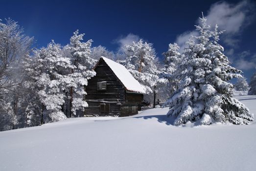 Mountain house in snow, winter sunny day