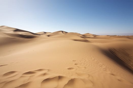 Sahara desert close to Merzouga in Morocco with blue sky and clouds