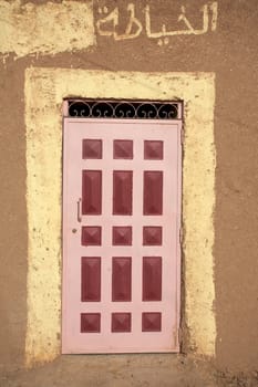 Close up of a typical Moroccan wood door painted with red squares