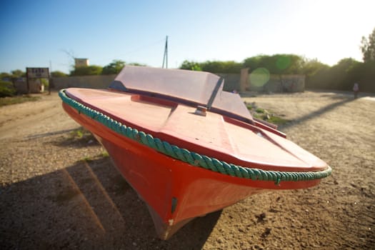 Small red boat in the harbour of Saint Louis with blue sky