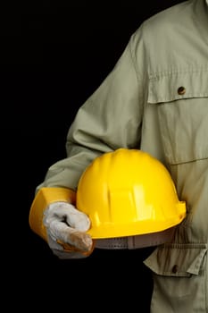 man holding yellow helmet over black background 