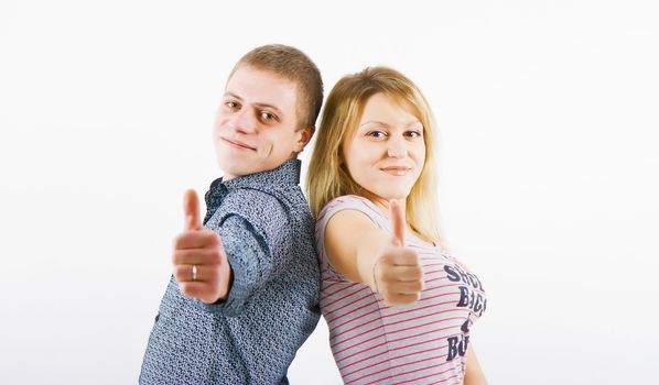 young happy couple with a thumbs up standing back to back
