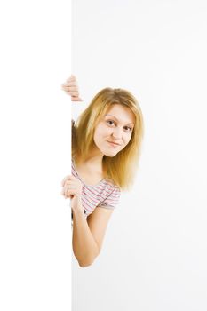 a young attractive girl looks out over a white sheet of paper
