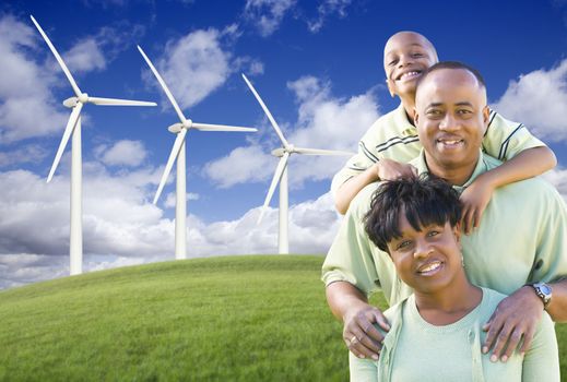 Happy African American Family and Wind Turbine with Dramatic Sky and Clouds.