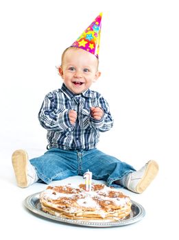 First birthday. Cute little boy in a cap with a birthday cake and a candle