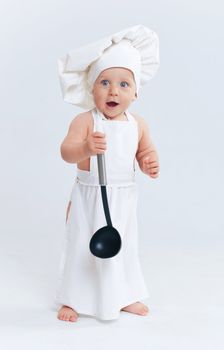 Little cook. Cute little boy in a suit of Food Boy with kitchen accessories. In the studio