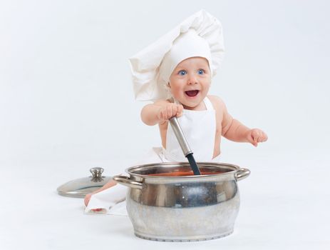 Little cook. Cute little boy in a suit of Food Boy with kitchen accessories. In the studio