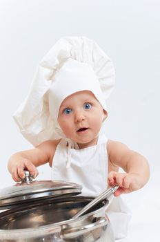 Little cook. Cute little boy in a suit of Food Boy with kitchen accessories. In the studio