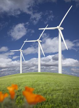 Wind Turbines Against Dramatic Sky, Clouds and California Poppies in the Foreground.
