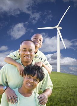 Happy African American Family and Wind Turbine with Dramatic Sky and Clouds.
