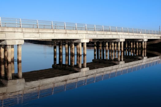 bridge over a calm cold river in kerry ireland reflected on a frosty morning