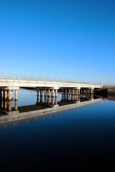 bridge over a calm cold river in kerry ireland reflected on a frosty morning with copy space