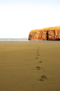 footprints on an empty beach on a beautiful winters day