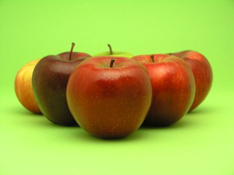 Group of red apples on green background
