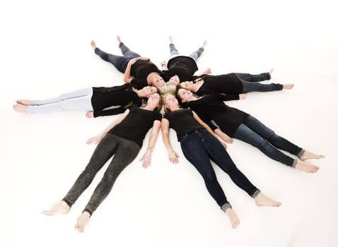 Group of Young Women lieing in a circle on white background