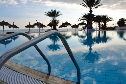 Swimming pool in tunisia with palms in background.
