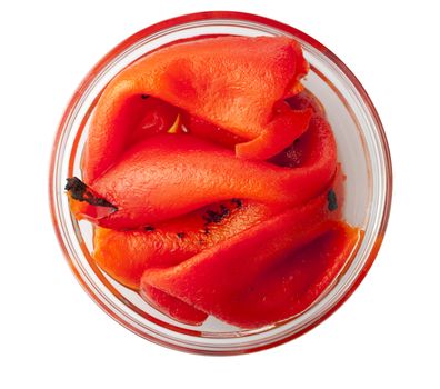 Roasted red peppers in glass bowl, shot from directly above and isolated on white.