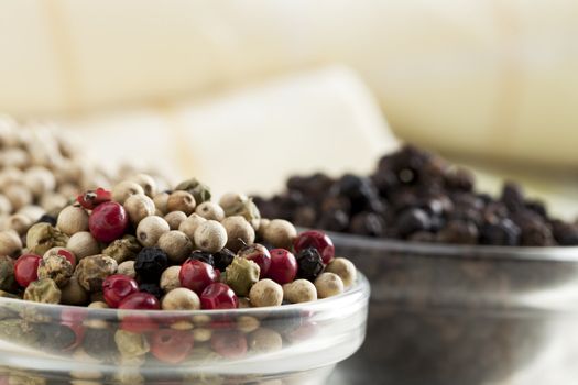 Close-up of mixed peppercorns in small glass bowl.