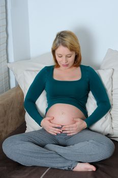 Young pregnant woman with hands on her abdomen.