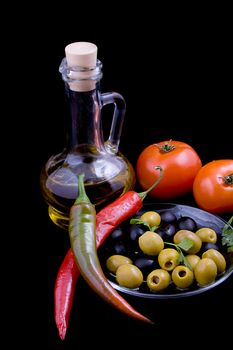 Olive oil, tomatoes, pepper and greens isolated on black
