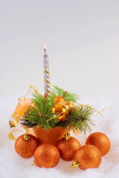Christmas orange spheres and silver candles on the white fur